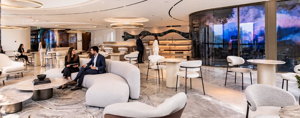 Team members talking in the lounge area of the Elite Merit office